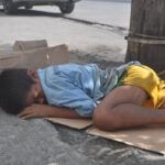 homeless boy sleeping on the street